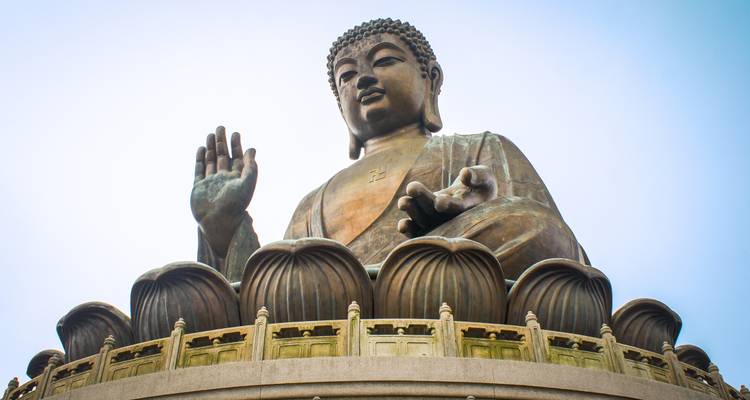 Une grande statue de Bouddha avec un ciel dégagé en arrière-plan.