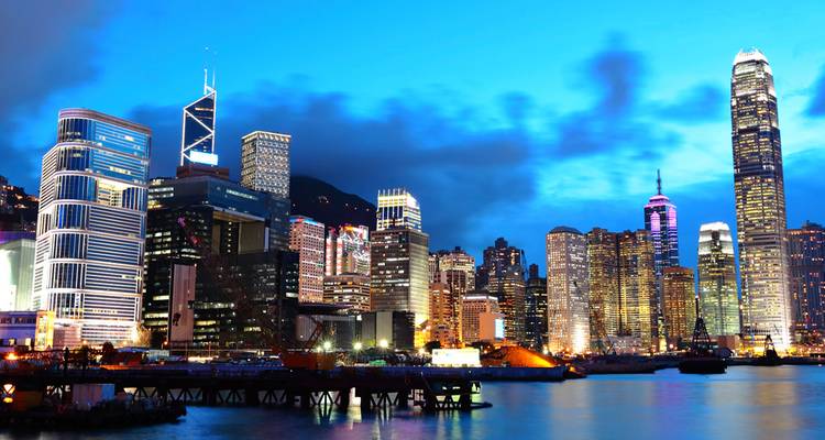 Los icónicos rascacielos de Hong Kong brillando a la hora azul junto al puerto de Victoria.