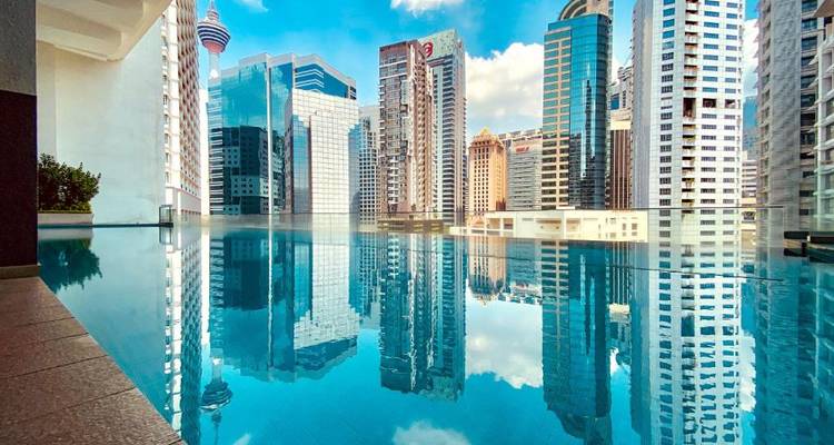 Swimming pool overlooking a city skyline with high-rise buildings.