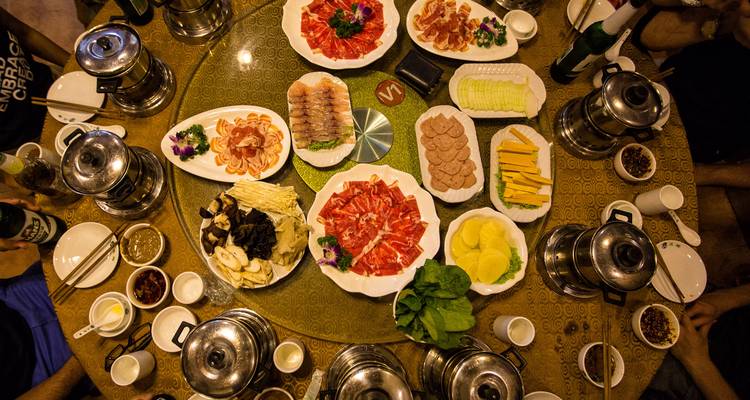 Vista aérea de carnes, hongos y vegetales para una animada fiesta de hot pot chino.
