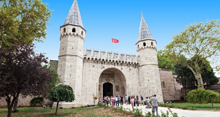 Los visitantes se reúnen en la entrada principal del Palacio de Topkapi de Estambul bajo una bandera turca.