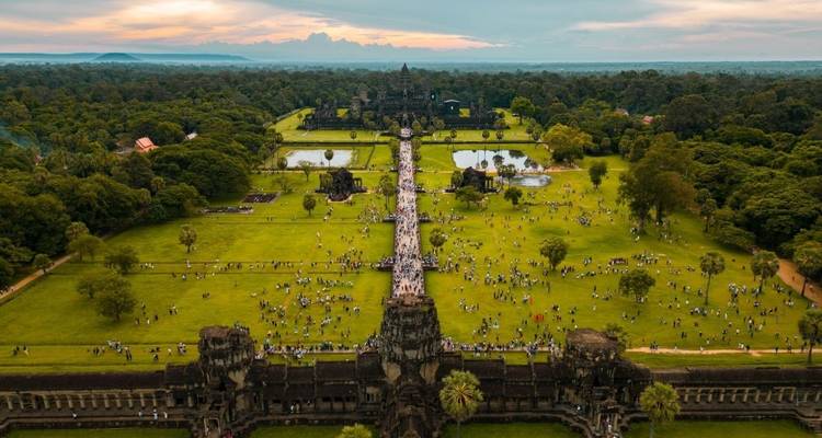 Aerial view of Angkor Wat with crowds and lush greenery.