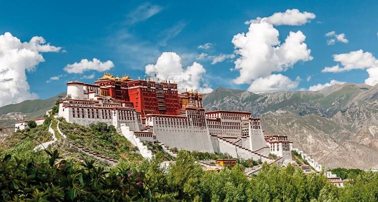 Palais du Potala sur une colline avec un ciel bleu clair et des montagnes.