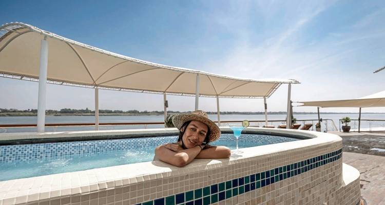 Person relaxing in a pool on the deck of a river cruise ship.