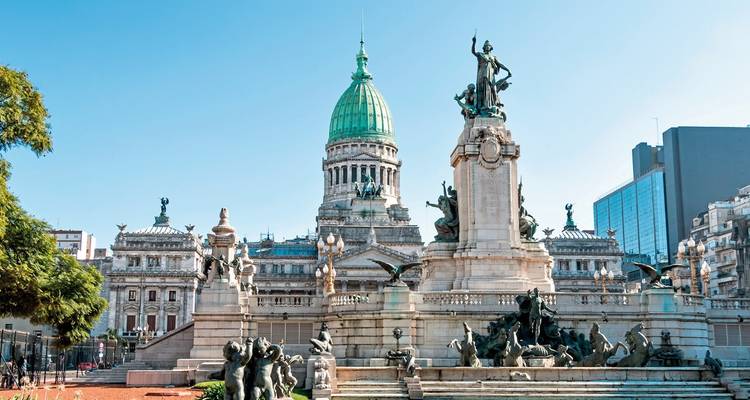 Historisches Gebäude mit Statue davor und blauem Himmel