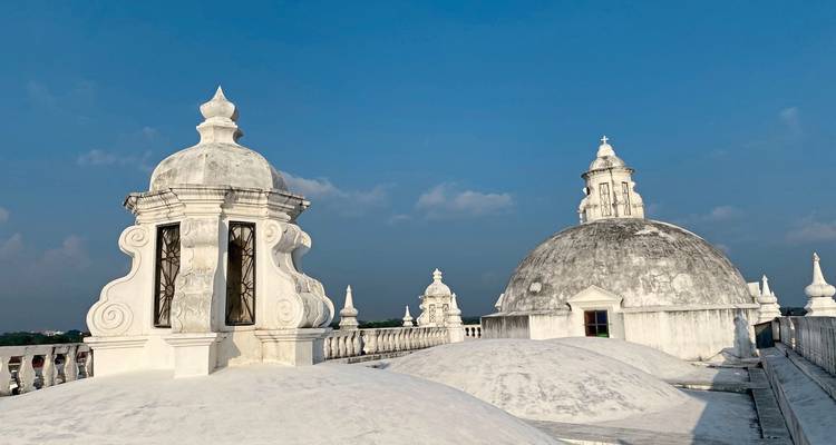 Roof of the Cathedral of León with bright domes against blue sky.