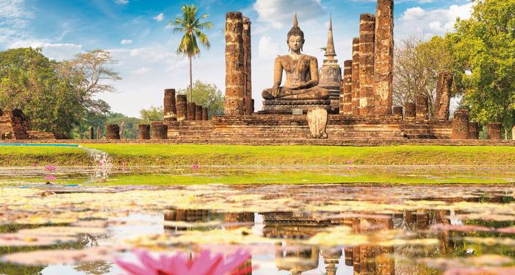 Estatua de Buda en el parque histórico de Sukhothai rodeada de ruinas.
