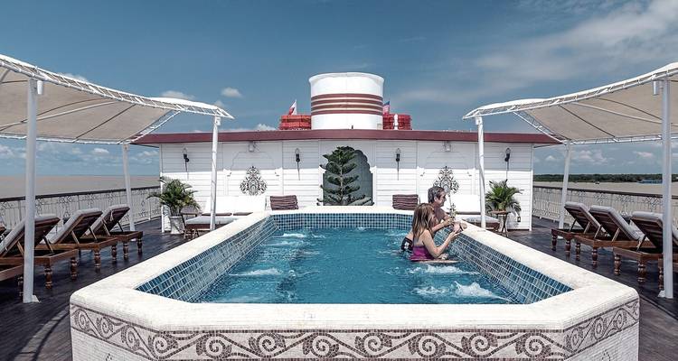 Pool auf dem Deck eines Kreuzfahrtschiffs mit sich entspannenden Menschen.