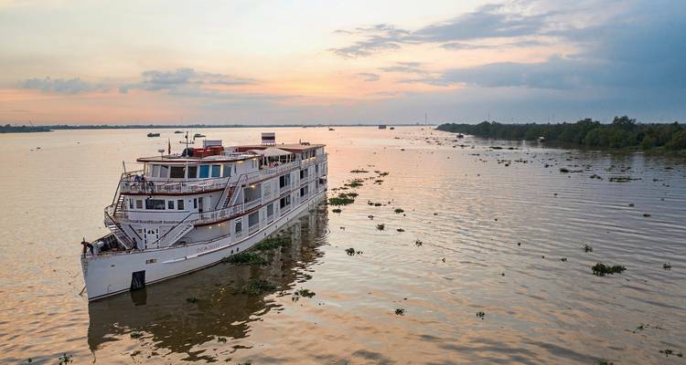 Luxus-Kreuzfahrtschiff auf dem Fluss während des Sonnenuntergangs.