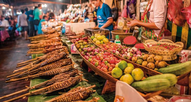 Local market with various foods and produce on display.