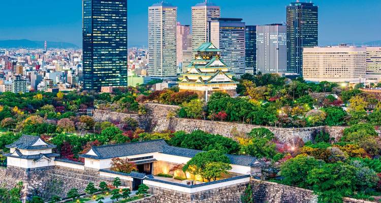 Osaka-Burg umgeben von städtischen Wolkenkratzern während der Dämmerung.