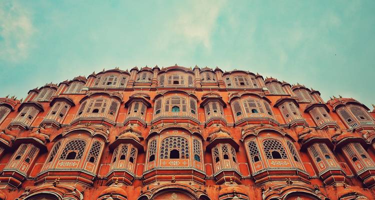 Ornate sandstone facade of a historic building with intricate windows.