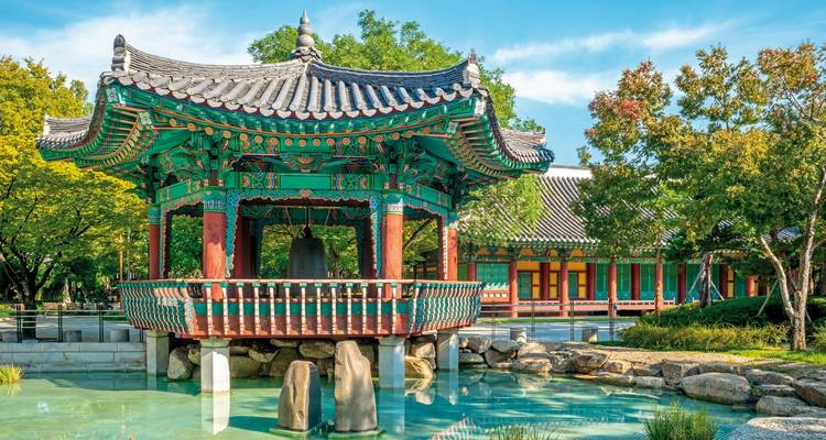 Traditioneller koreanischer Pavillon umgeben von Wasser und Bäumen