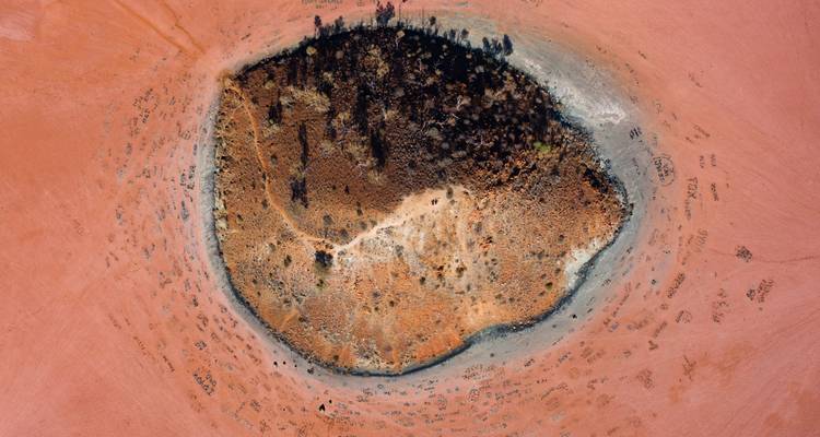 Luchtfoto van een drooggevallen meer met donkere vlekken.