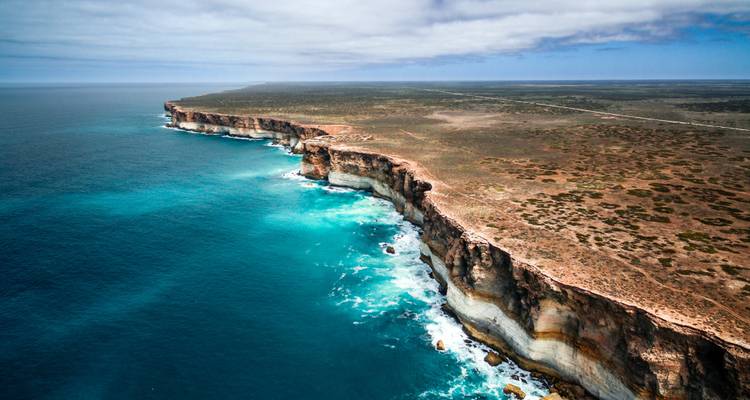 Luchtfoto van ruige kustrotsen en oceaan.