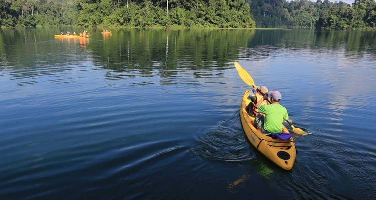 Canoeing on a serene lake surrounded by dense forest.