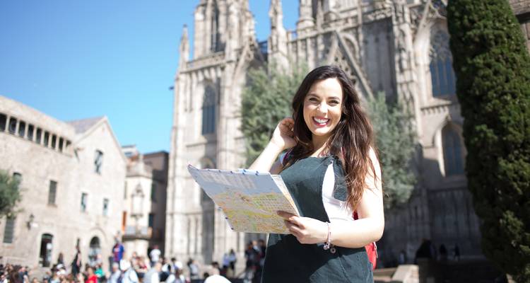 Frau hält eine Karte vor historischen Gebäuden.