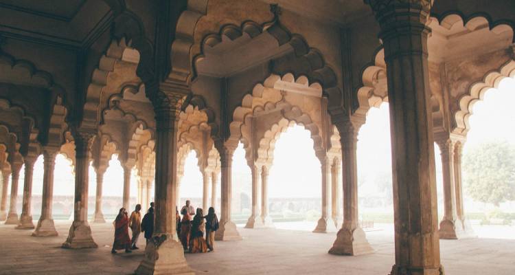 Les visiteurs se rassemblent sous les arches ornées de style moghol à l'intérieur d'un pavillon historique en grès.