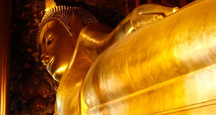 Detaillierte Nahaufnahme des goldenen Gesichts und der Schulter des berühmten liegenden Buddha von Bangkok.