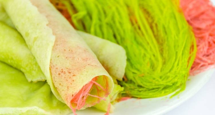 Buntes thailändisches Dessert mit gerollten Süßigkeiten und gesponnener Zuckerwolle in Pastellfarben.