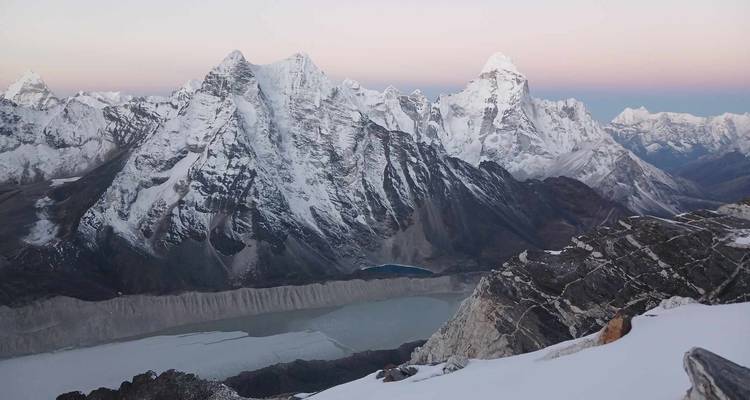 Bergige Landschaft mit einem See und Schnee.