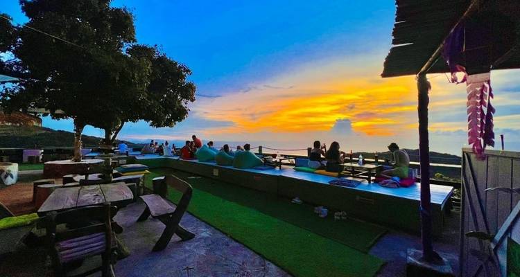 Mensen die genieten van een zonsondergangzicht vanaf een terras.