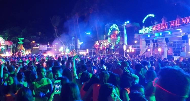 Drukke nachtfeest met felle neonlichten.