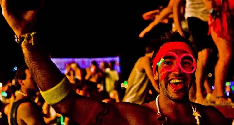 Persoon met neon bril opgewonden op een feest.