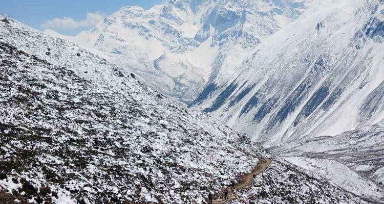 Paysage enneigé avec un sentier menant vers les montagnes.