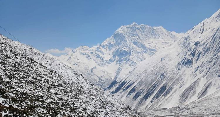 Des sommets enneigés qui s'élèvent dans le ciel bleu.