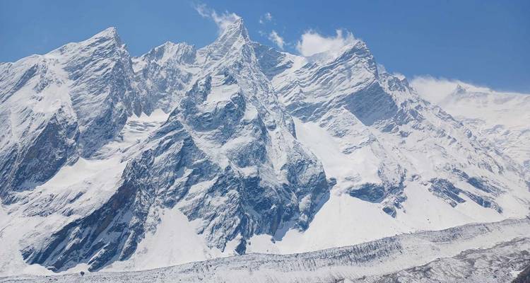 Grande chaîne de montagnes enneigée sur un ciel dégagé.