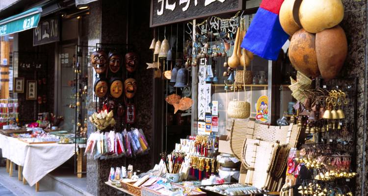 Traditionelles koreanisches Kunsthandwerk-Geschäft mit Masken, Glocken und Souvenirs an einer belebten Straße.