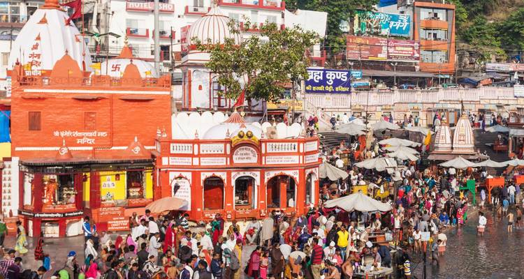 Eine überfüllte Ghats-Szene mit einem Tempel im Hintergrund.