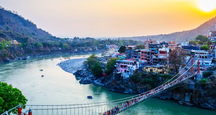 Malerischer Blick über Rishikesh mit einer Brücke und einem Fluss bei Sonnenuntergang.