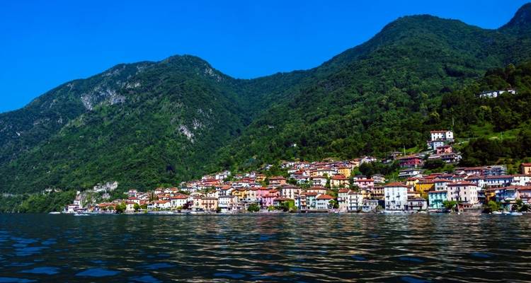 Colorful village by the mountainside along a lake.