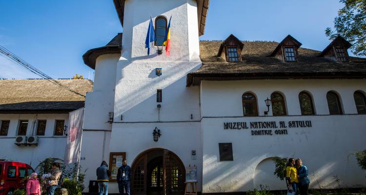 Weisse Fassade mit Strohdach des Eingangs zum Dorfmuseum von Bukarest an einem sonnigen Tag.