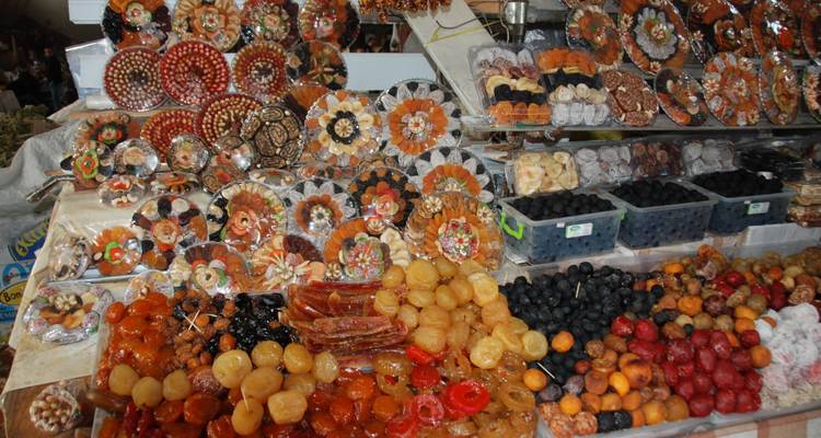 Étalage coloré de fruits secs et de confiseries sur un marché.