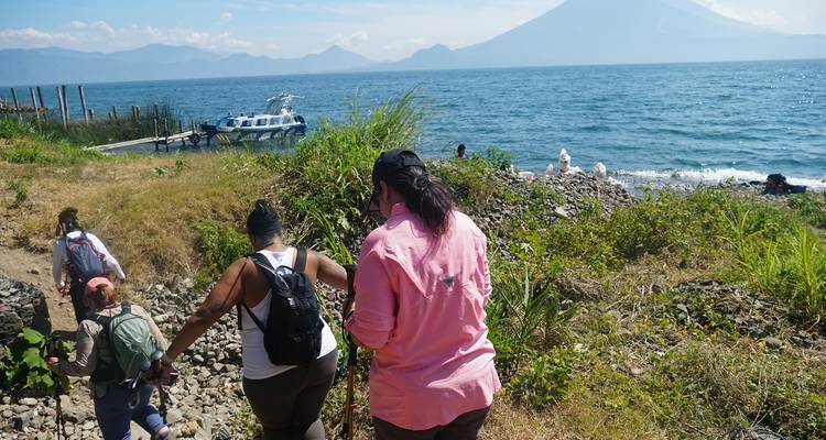 Groep mensen die wandelen in de buurt van een meer en berg.