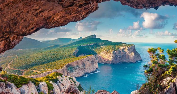 Des falaises côtières spectaculaires et une mer bleue vues depuis l'ouverture d'une grotte sur le littoral accidenté de la Sardaigne