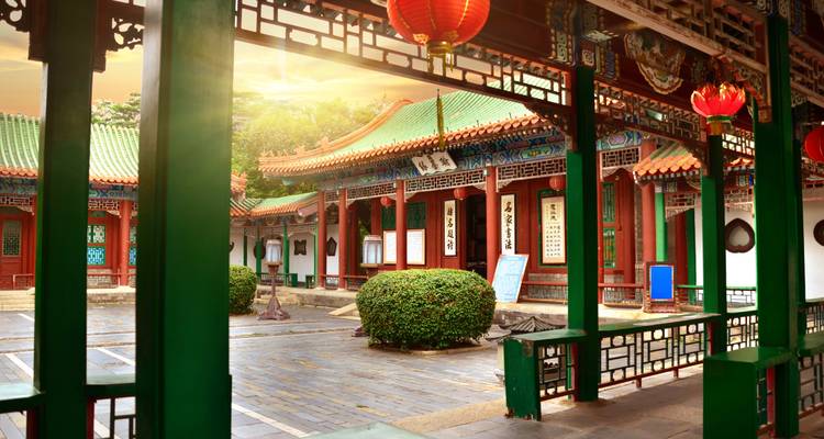 Traditional Chinese architecture with lanterns under a golden sunset.