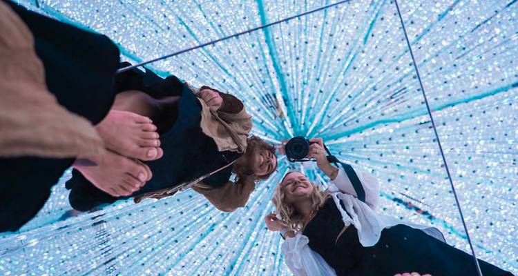 People taking selfies in an illuminated art installation.