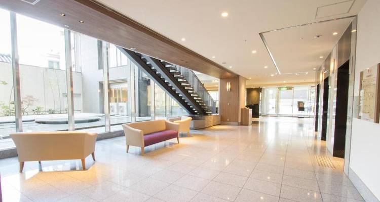 Geräumige Hotellobby mit großen Fenstern und modernen Möbeln.