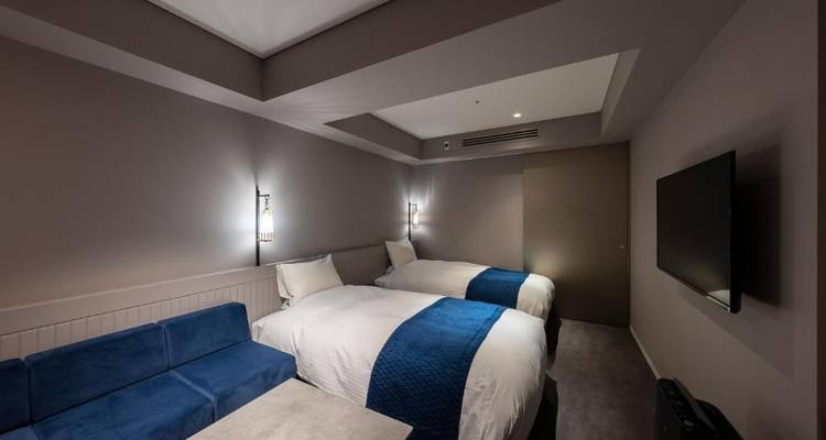 Hotelzimmer mit zwei Betten und moderner Einrichtung.