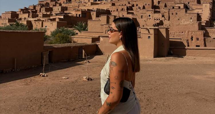 Person exploring traditional clay buildings in a desert village.
