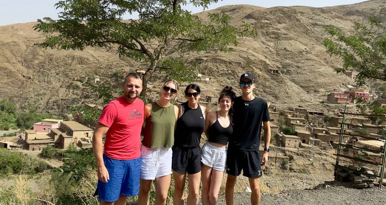 A group of friends posing in front of a mountainous landscape.
