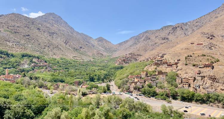 Mountain valley with scattered villages and green vegetation.