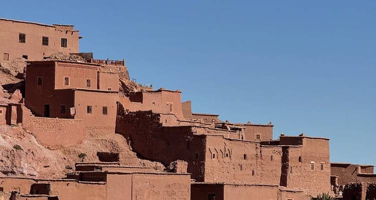 Cluster of earthen buildings against a clear sky.