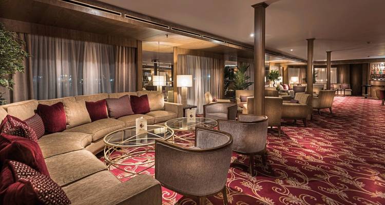 Espace salon luxueux avec sièges moelleux et grandes fenêtres.