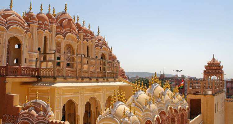 Komplexe rosa Sandsteinfassade des Hawa Mahal in Jaipur unter klarem Himmel.