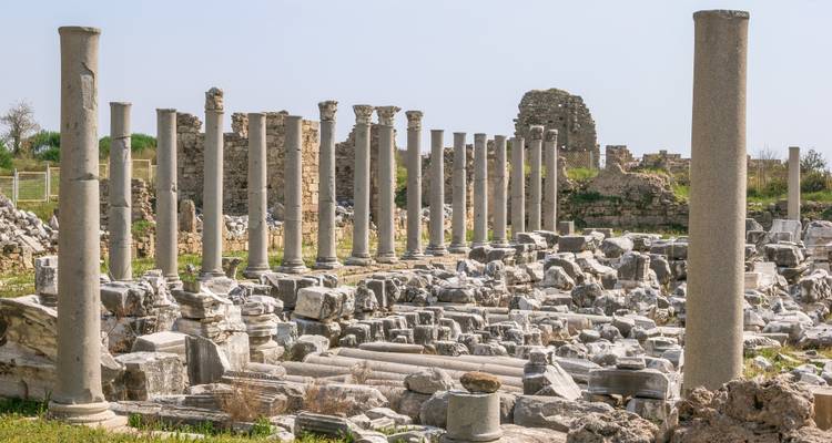 Ruines de colonnes de style romain antique sous un ciel clair.